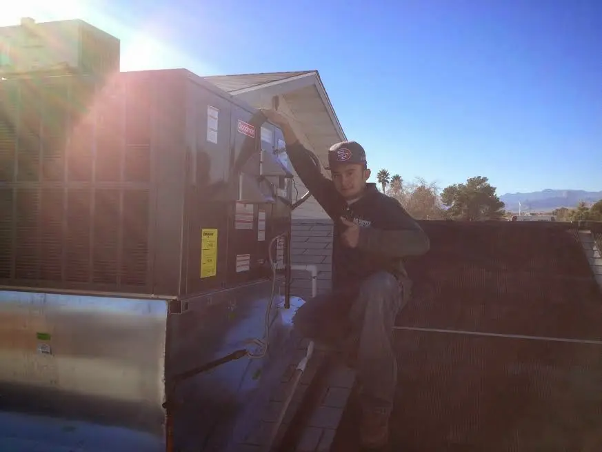 HVAC technician performing HVAC Inspection on a rooftop unit in Dakota Ridge